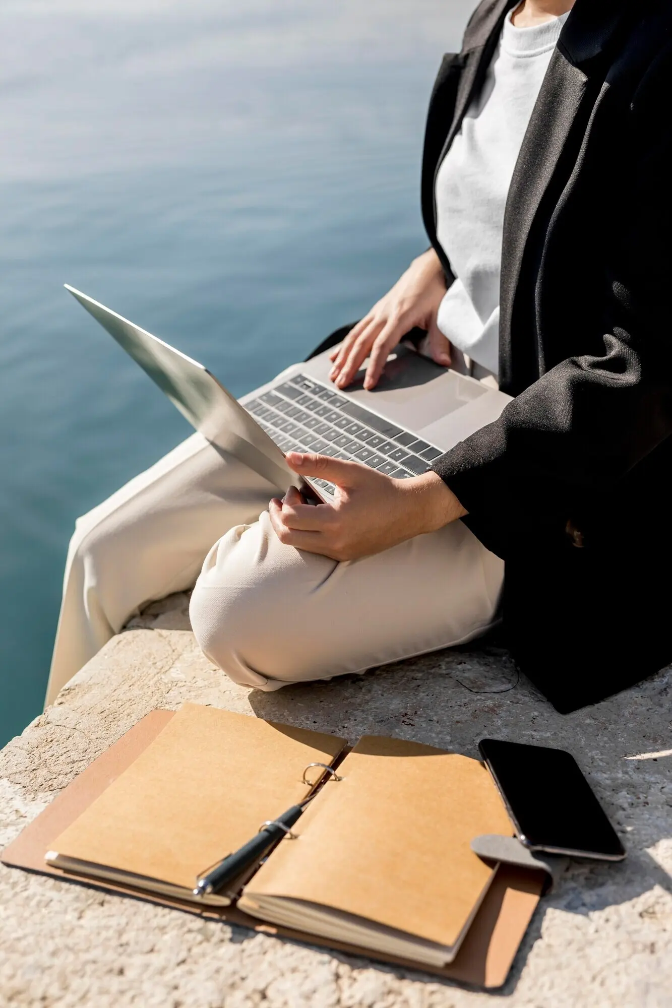 A fashionable woman working outdoors on a sunny day.